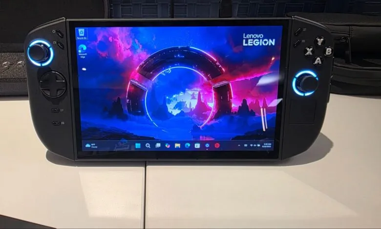 Lenovo Legion handheld gaming PC with vibrant purple and blue sci-fi wallpaper, showcasing its buttons and controls.