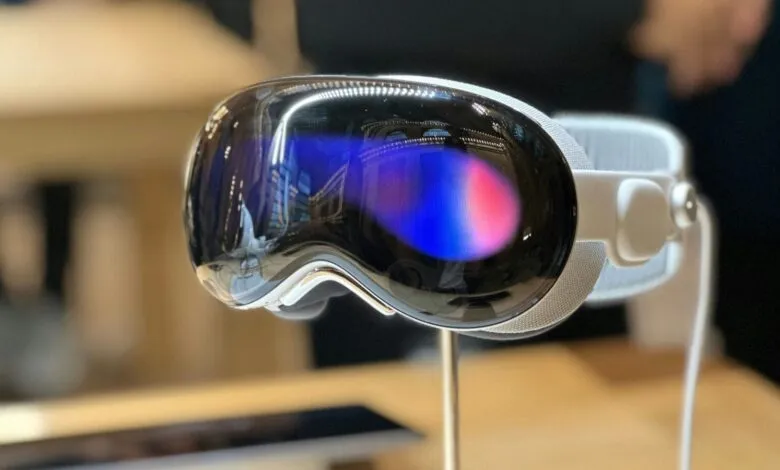 Close-up of a sleek, white VR headset with reflective lenses showing a blurry blue and pink reflection.