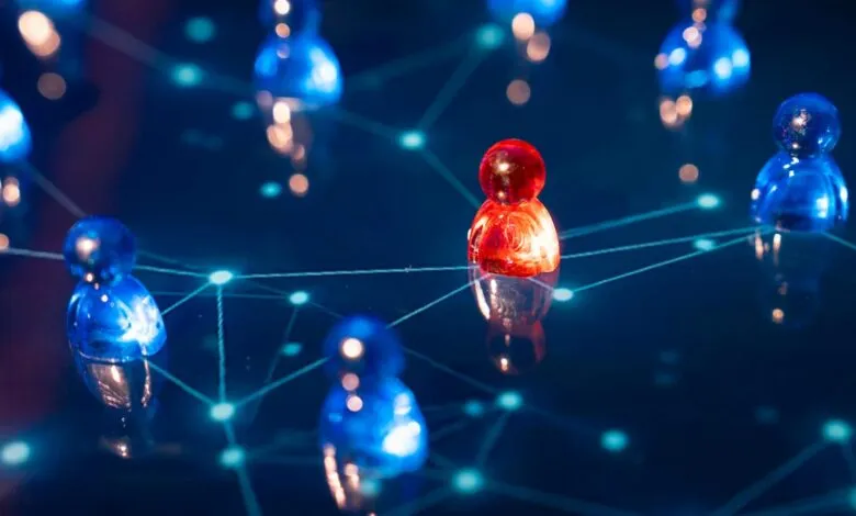 A single red pawn stands out among many blue pawns connected by a network.