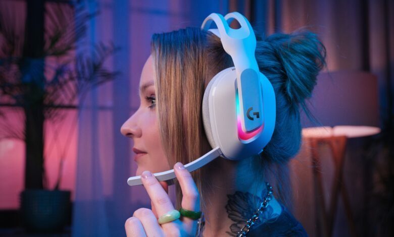 Woman wearing white Logitech gaming headset with RGB lighting, close-up profile view.