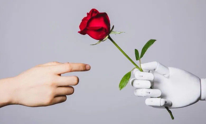 A robotic hand offers a red rose to a human hand. AI and human interaction concept.