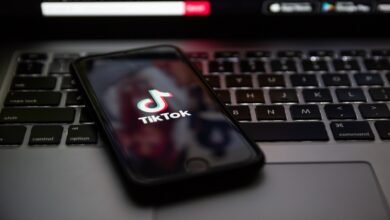 Smartphone displaying the TikTok logo on a laptop keyboard.