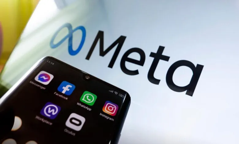 Meta logo displayed on a screen, with a smartphone showing Facebook, Instagram, WhatsApp, and Messenger icons.