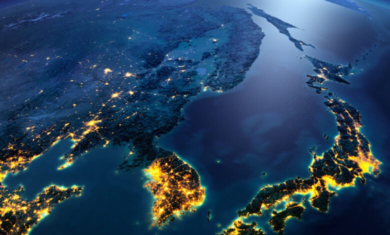 Aerial view of East Asia at night, showing illuminated cities across Japan and Korea.