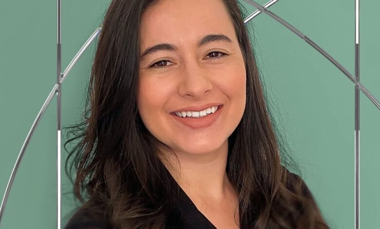 Smiling portrait of Carolina Moreira Delci against a sage green background with a geometric silver design.