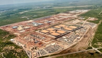 Aerial view of a large-scale construction site, showing numerous buildings under construction and extensive land preparation.
