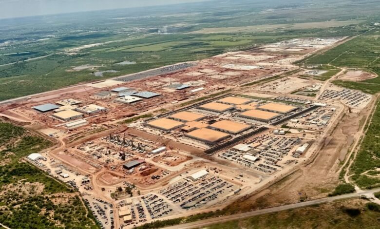 Aerial view of a large-scale construction site, showing numerous buildings under construction and extensive land preparation.
