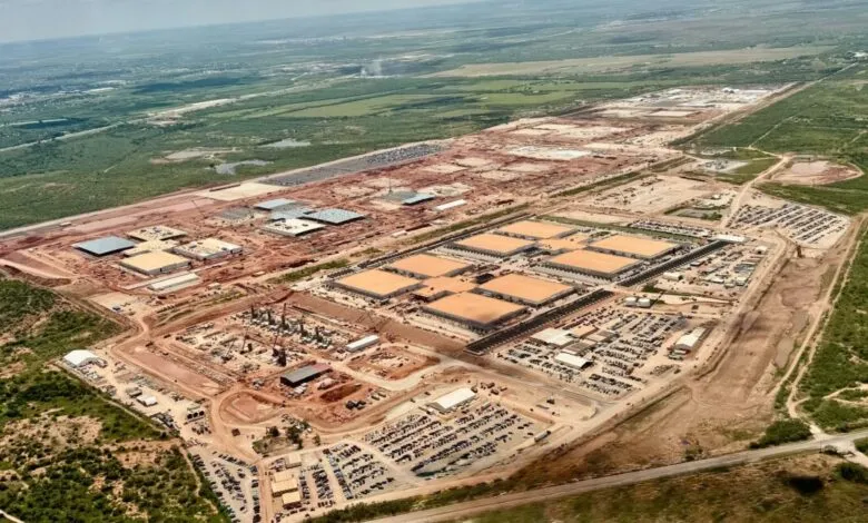Aerial view of a large-scale construction site, showing numerous buildings under construction and extensive land preparation.