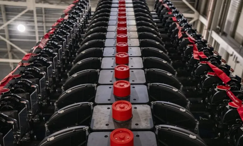 Close-up view of numerous black satellite dishes with red accents arranged in a vertical row.