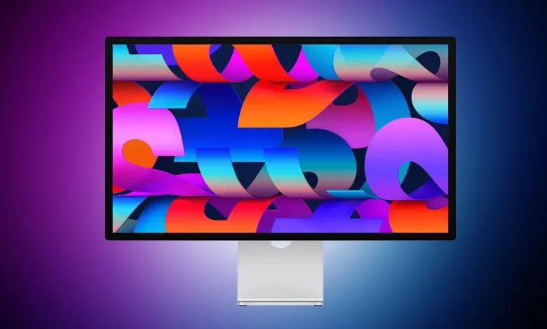 A modern computer monitor displaying a vibrant, abstract wallpaper with flowing ribbons of color.