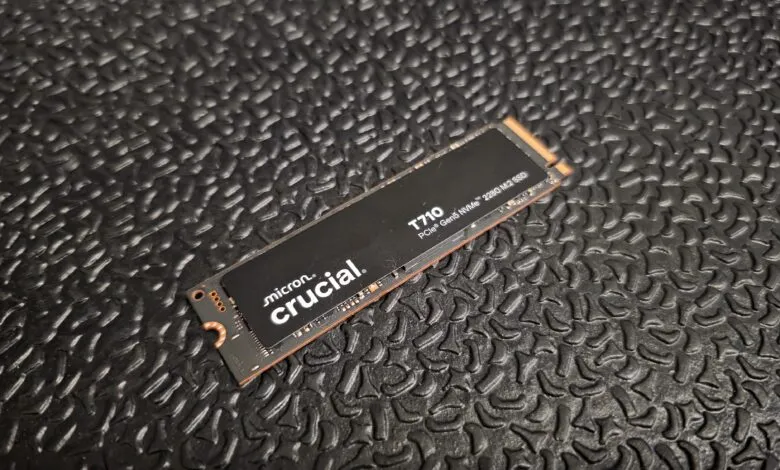 Close-up of a Crucial T710 PCIe Gen5 NVMe 2280 M2 SSD on a textured black surface.