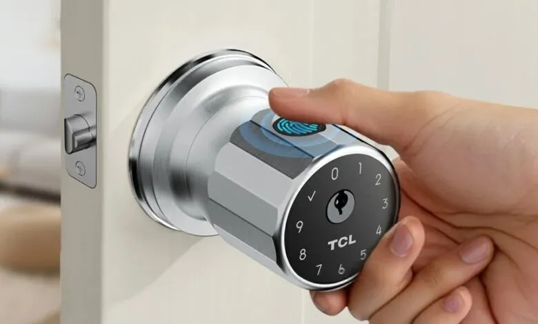 Hand using fingerprint scanner on a silver TCL smart door lock with keypad.