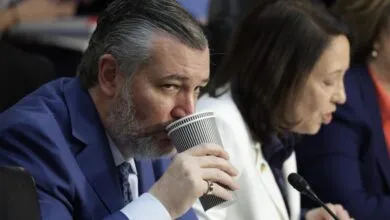 Close-up of Senator Ted Cruz drinking from a paper cup during a Senate hearing.
