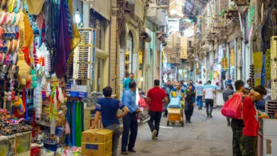Bustling Tehran Grand Bazaar: People browse colorful goods in a narrow, vibrant alleyway.