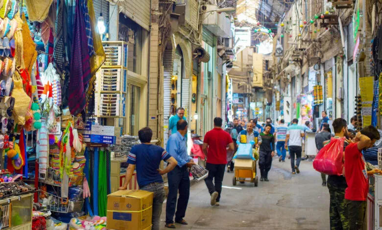 Bustling Tehran Grand Bazaar: People browse colorful goods in a narrow, vibrant alleyway.