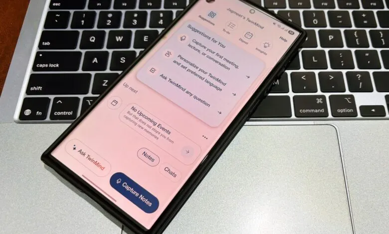 Smartphone displaying the TwinMind app interface on a laptop keyboard. The app shows options for note-taking, scheduling, and AI assistance.