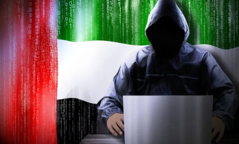 A hooded figure sits at a laptop, the UAE flag and binary code in the background, suggesting cybercrime or hacking.