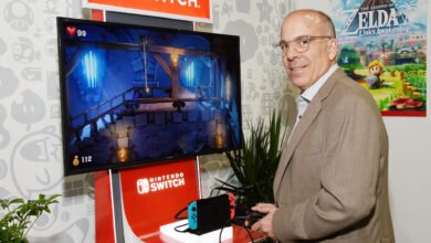 Man in a suit playing Luigi's Mansion 3 on a Nintendo Switch.
