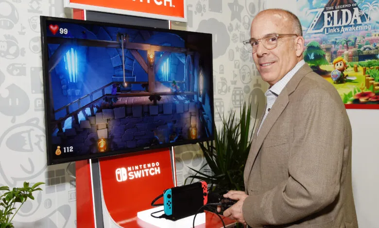 Man in a suit playing Luigi's Mansion 3 on a Nintendo Switch.