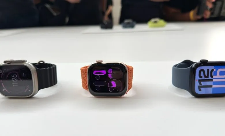 Three Apple Watches in silver, gold, and space gray with different watch bands displayed on a white surface.
