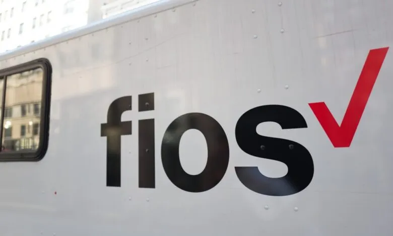 Verizon Fios logo on a white truck, black lettering with a red checkmark.