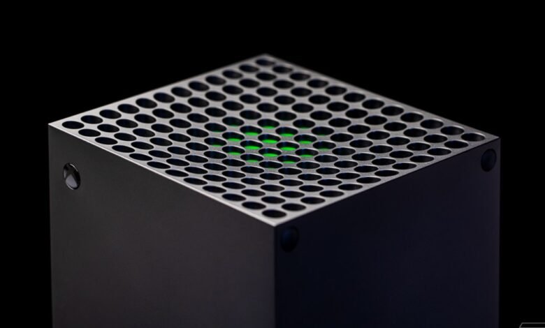 Close-up of a black Xbox Series X console, showing its unique perforated top and a glowing green light.