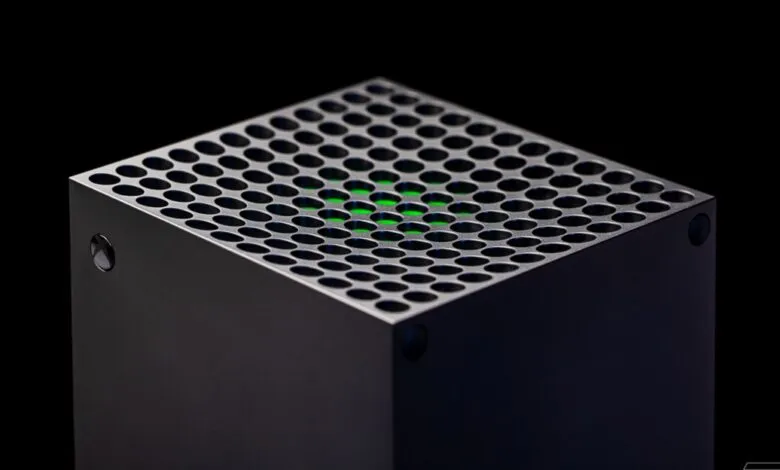 Close-up of a black Xbox Series X console, showing its unique perforated top and a glowing green light.