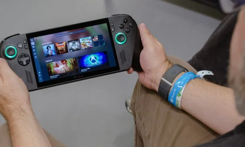 Person holding a handheld gaming device with a vibrant game library displayed on screen.