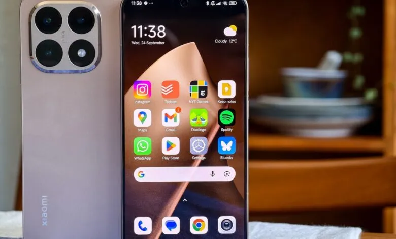 Close-up of a Xiaomi smartphone with a quad-camera system and a screen displaying various app icons.