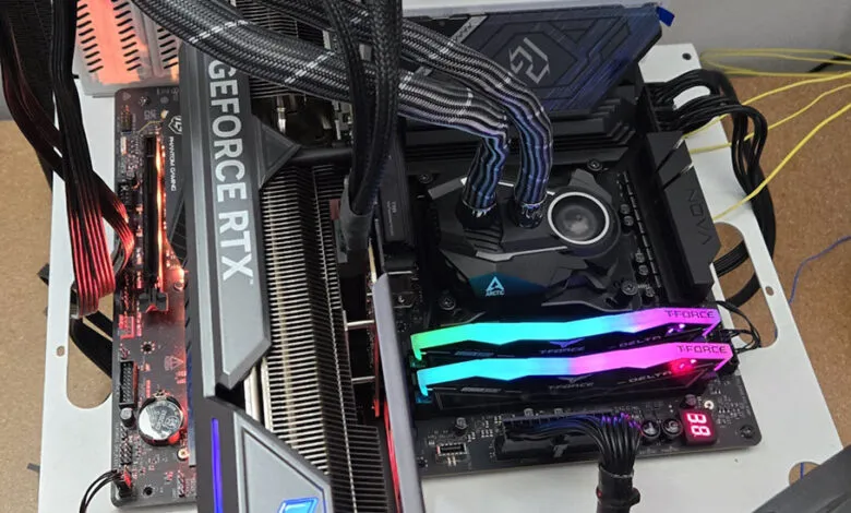 Close-up of a computer motherboard with a GeForce RTX graphics card, RGB RAM, and temperature sensors.