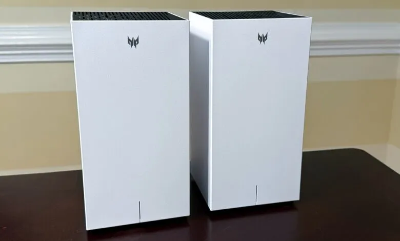Two white MSI computer speakers sit on a dark brown table.