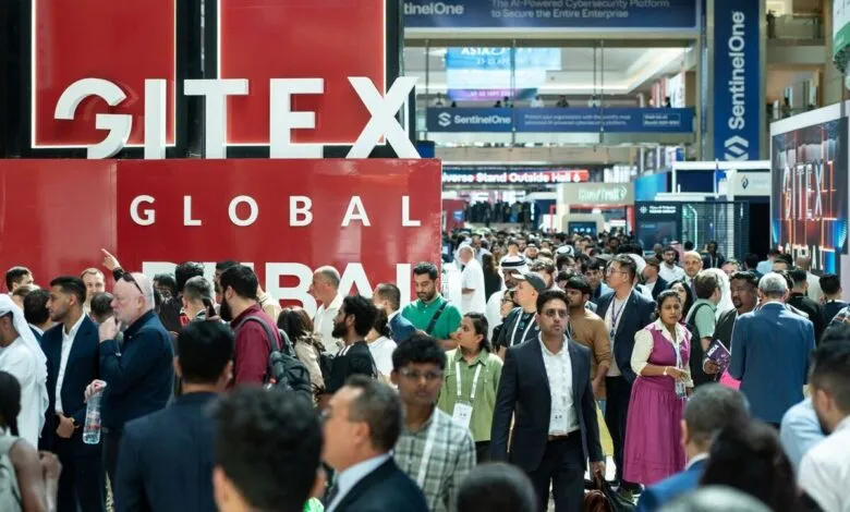 Crowd of people at GITEX GLOBAL event with large red signage.