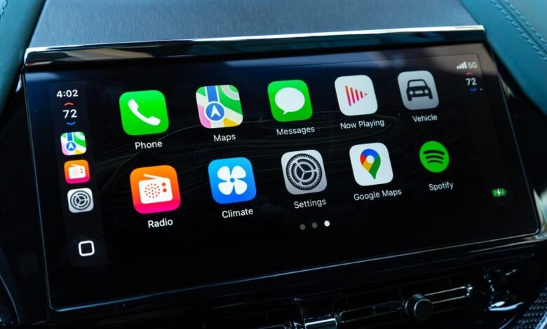 Close-up of a car's infotainment screen displaying Apple CarPlay interface with app icons.