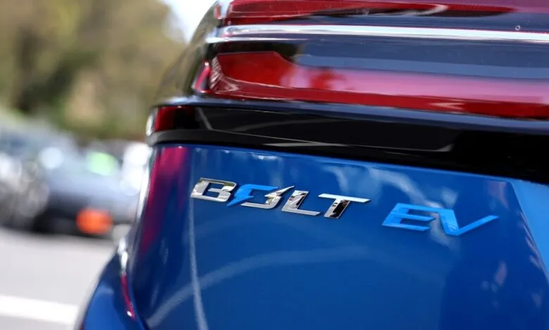 Close-up of the 'Bolt EV' emblem on a bright blue electric car.