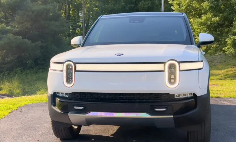 Front view of a white Rivian R1S electric SUV parked outdoors.