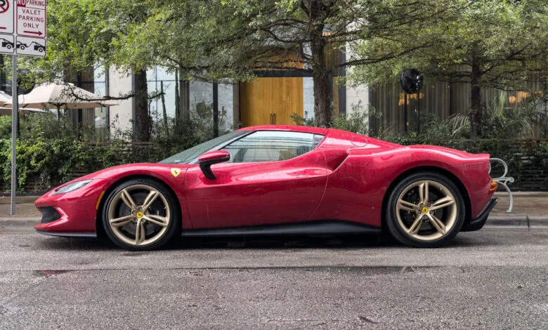 Side profile of a red Ferrari 296 GTB parked on a wet street.