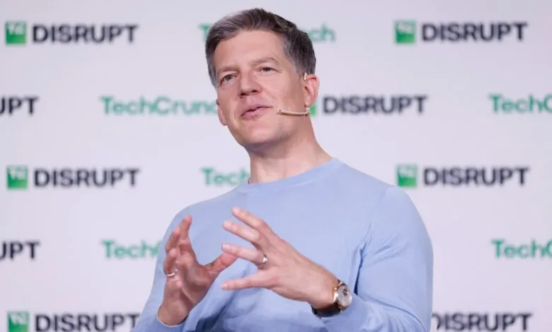 Man in light blue sweater speaking at TechCrunch Disrupt event