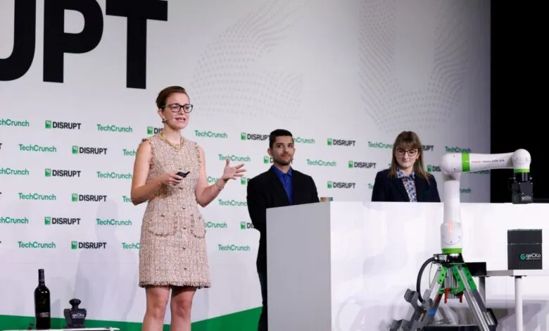 Woman presenting at TechCrunch Disrupt with robotic arms on display