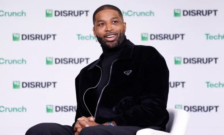 Tristan Thompson smiles while sitting on a white chair at a TechCrunch Disrupt event.