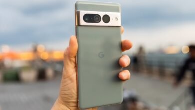 Close-up of a hand holding a Google Pixel 7 Pro smartphone with a sage green finish.