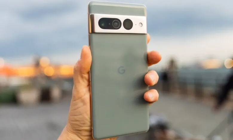 Close-up of a hand holding a Google Pixel 7 Pro smartphone with a sage green finish.
