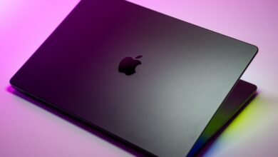 Close-up of a dark gray Apple MacBook Pro with the illuminated logo.