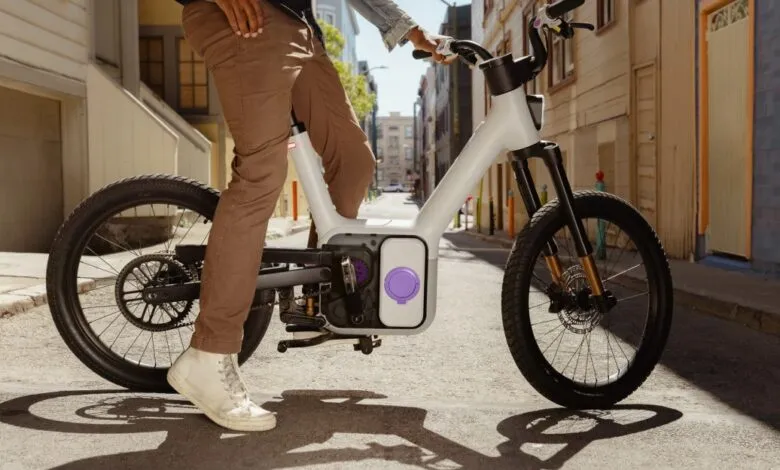 Person on a modern white electric bicycle in a city street.