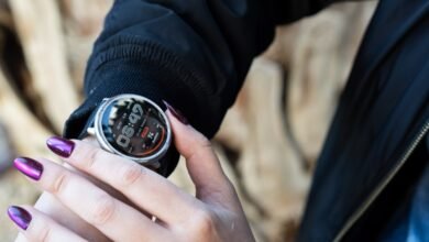 Close-up of a person's hand with purple nail polish checking a smartwatch.