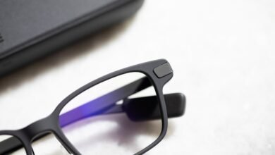 Close-up of matte black eyeglasses with a protective case in the background.