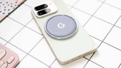Close-up of a light green smartphone with a circular Google charger attached to its back.