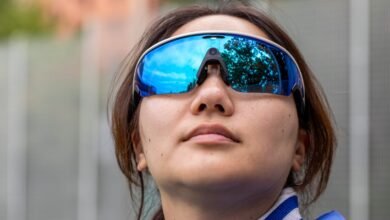 Close-up of a woman wearing large, reflective blue sports sunglasses.