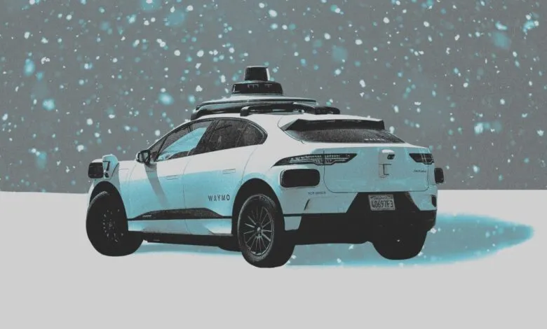 A white Waymo autonomous vehicle driving in a snowstorm.
