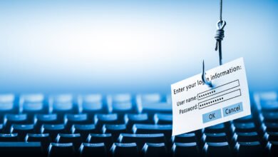 A fishing hook dangles a login form over a blurred keyboard, symbolizing cyber threats.