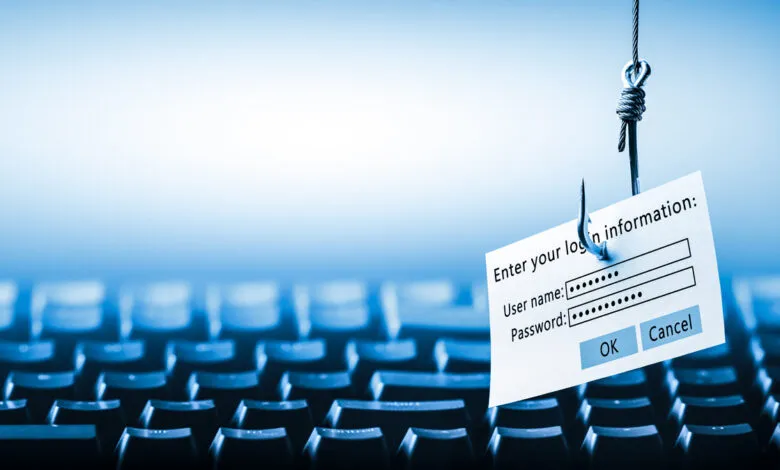 A fishing hook dangles a login form over a blurred keyboard, symbolizing cyber threats.
